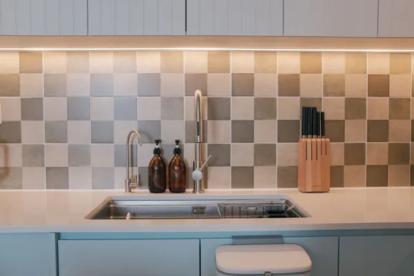 Clean kitchen with a tiled splashback over the sink